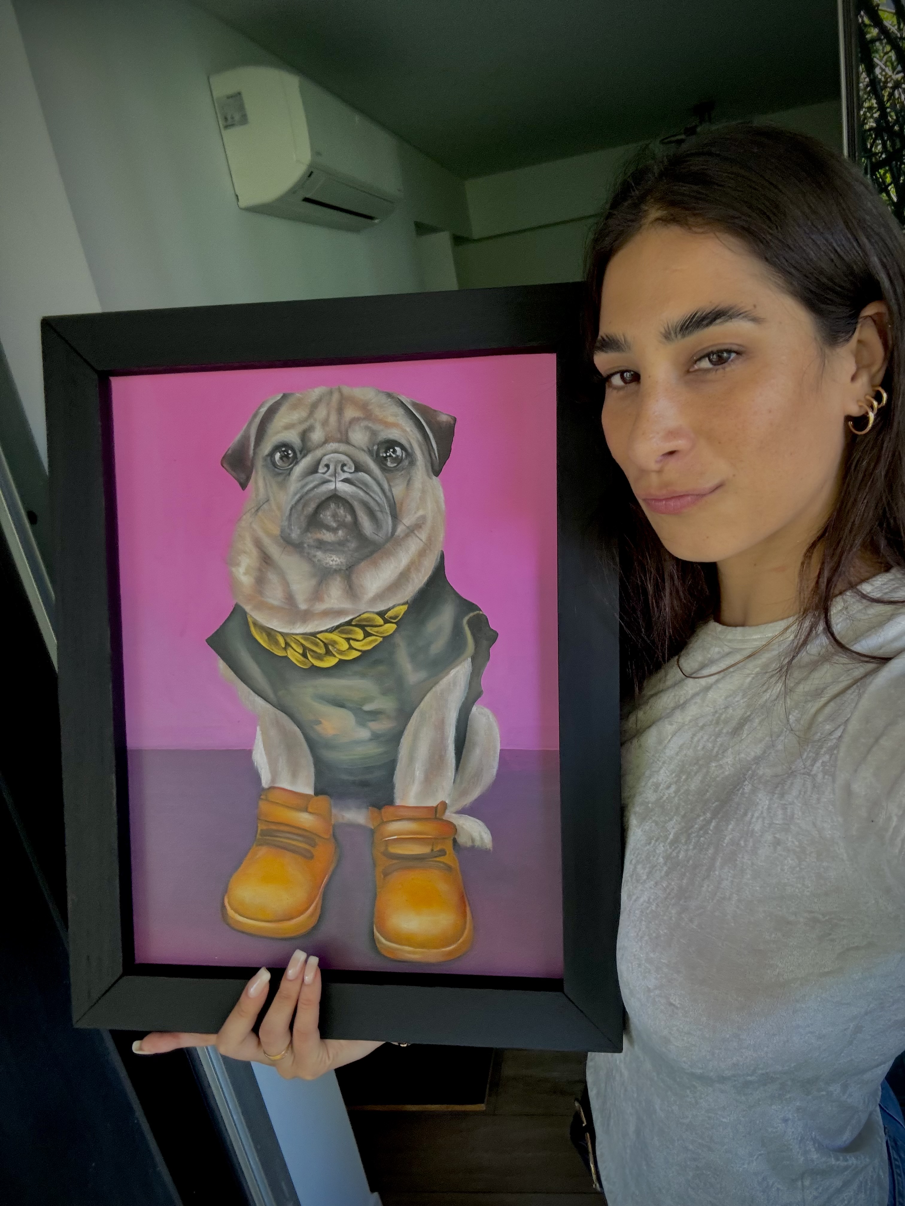 Brenda Cisnero (Juana Perfecta), artista de La Factoría, con uno de sus retratos